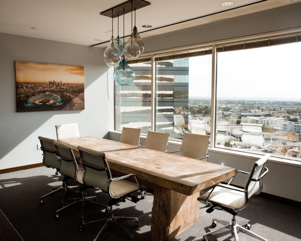 A long table with chairs in front of a window.