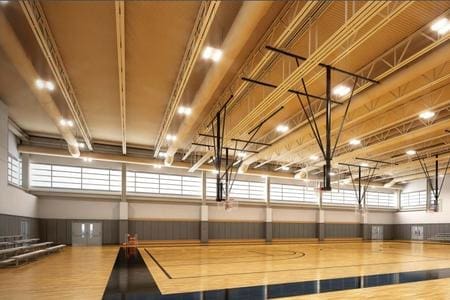 A gym with wooden floors and a basketball court.