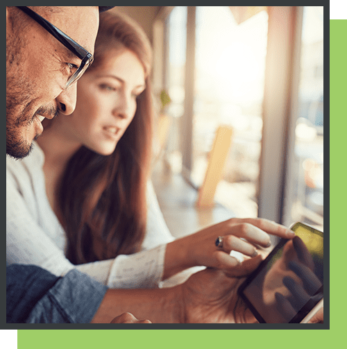 A man and woman looking at an ipad.