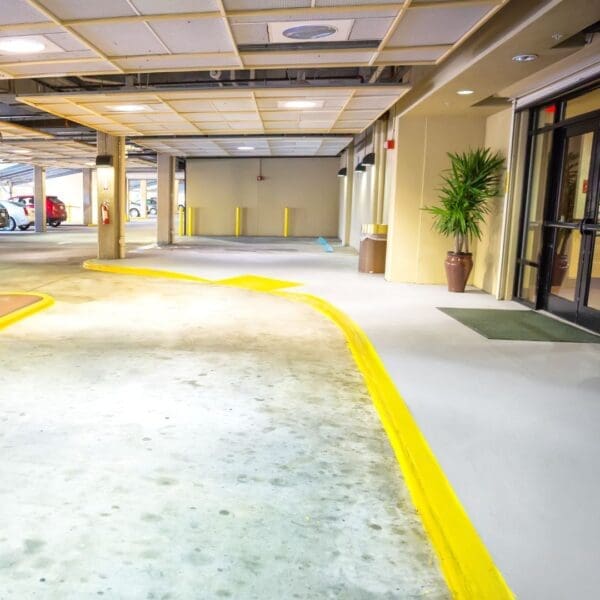 A parking garage with yellow lines on the floor.