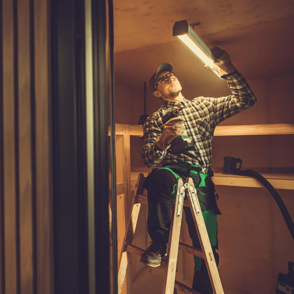 A man on a ladder looking at the light