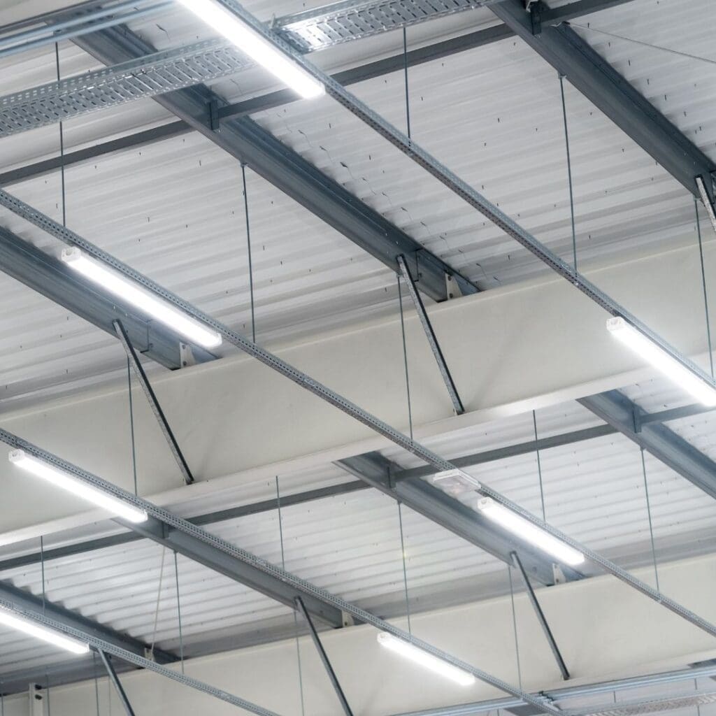 A ceiling with many lights and some metal beams