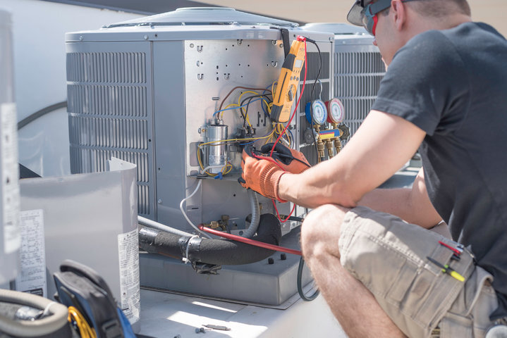HVAC tech working on unit