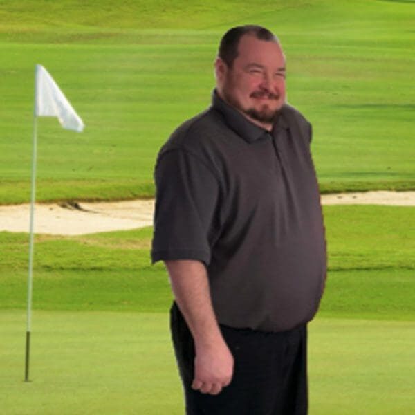 A man standing on top of a golf course.